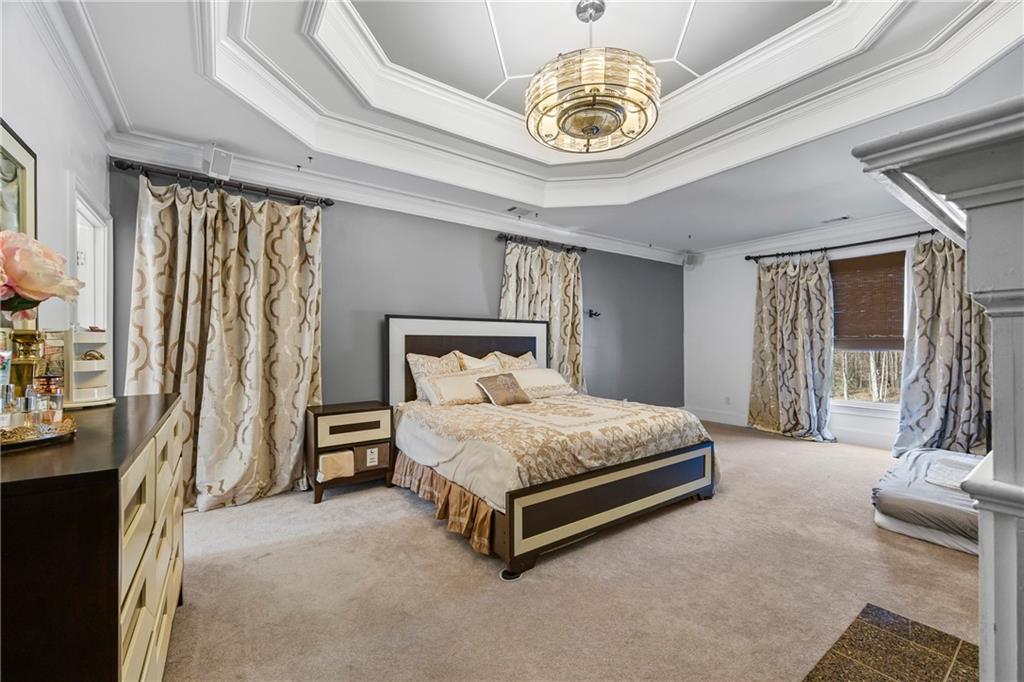 2668 New Hope Road Dacula, GA 30019 - Photo 18 of 65 a bedroom with a bed and a chandelier