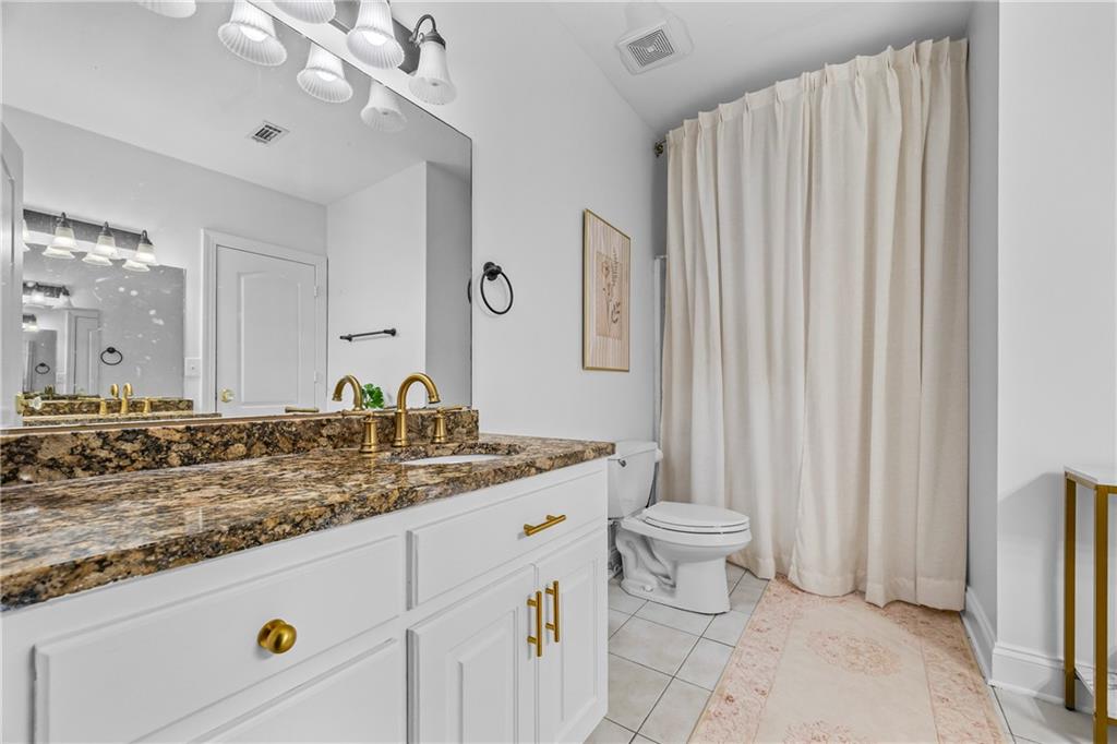 2668 New Hope Road Dacula, GA 30019 - Photo 43 of 65 a bathroom with a granite countertop sink a toilet and a mirror