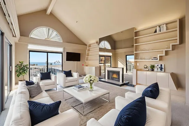 a living room with furniture fireplace and a large window