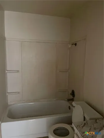 a bathroom with a shower and toilet