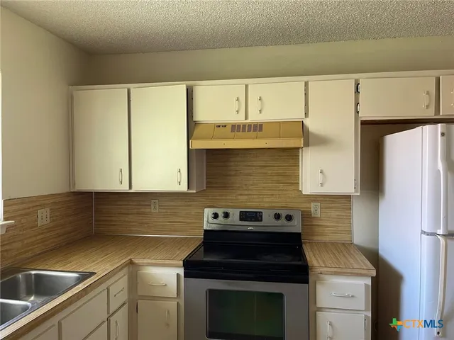 a kitchen with stainless steel appliances granite countertop a sink and a window