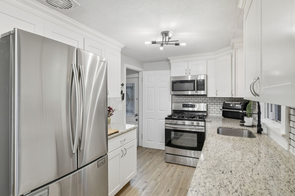 150 Drexel Street Springfield, MA 01104 - Photo 9 of 27 a kitchen with stainless steel appliances granite countertop a refrigerator stove and microwave
