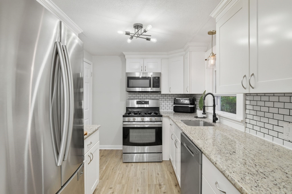 150 Drexel Street Springfield, MA 01104 - Photo 10 of 27 a kitchen with stainless steel appliances granite countertop a sink stove and refrigerator