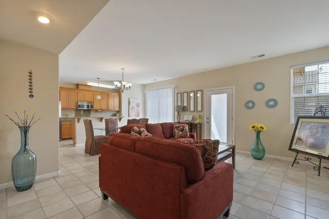 a living room with furniture and a dining table with kitchen view