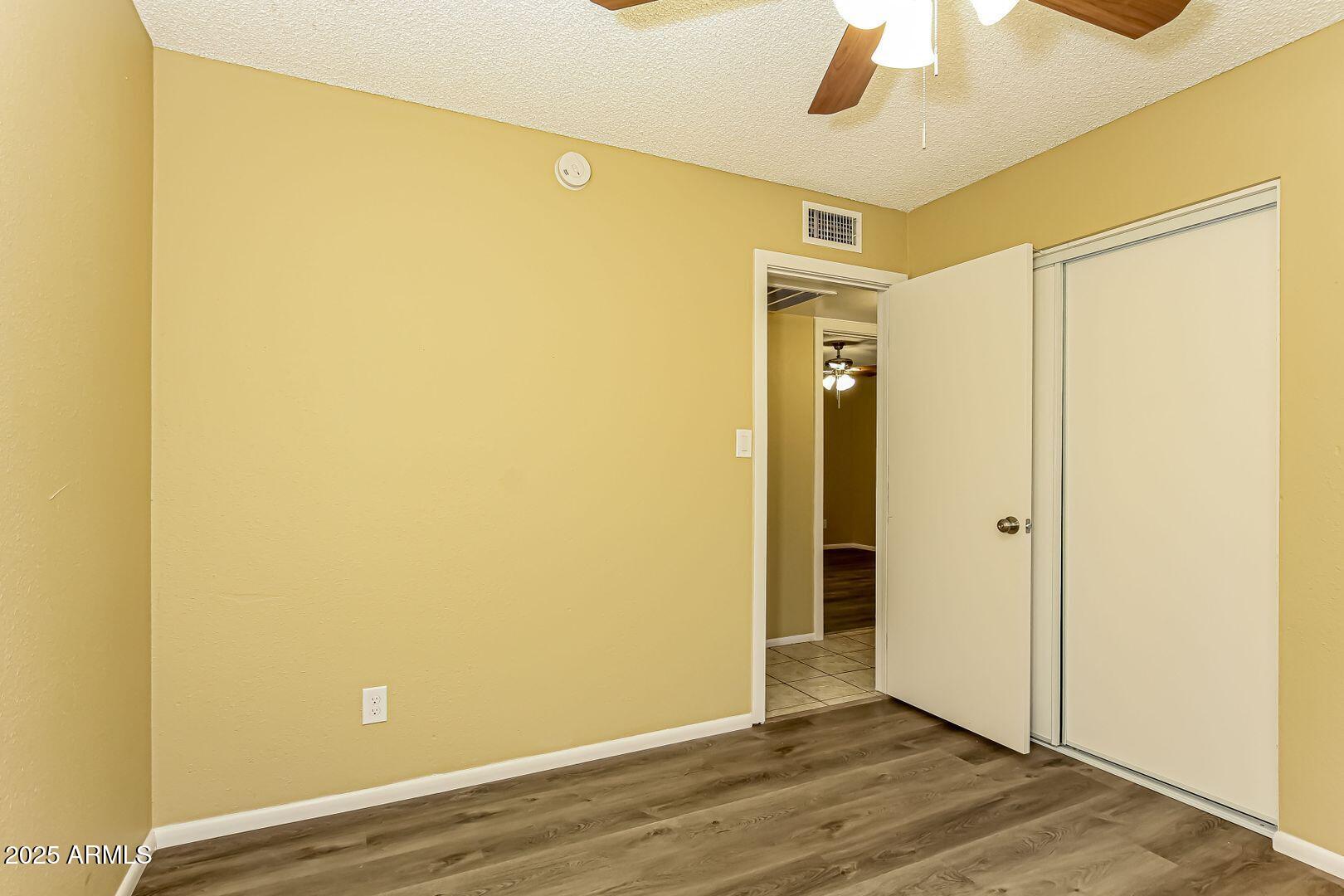 4610 North 75th Drive Phoenix, AZ 85033 - Photo 11 of 14 a view of an empty room with wooden floor