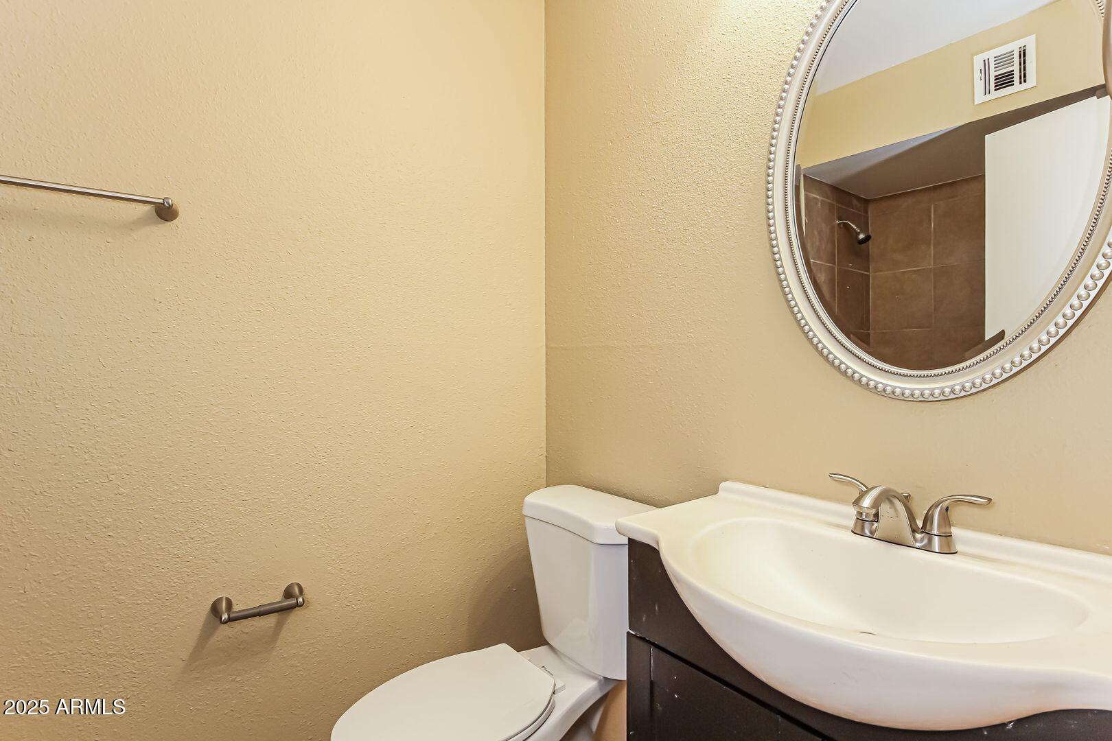 4610 North 75th Drive Phoenix, AZ 85033 - Photo 12 of 14 a bathroom with a sink mirror and toilet