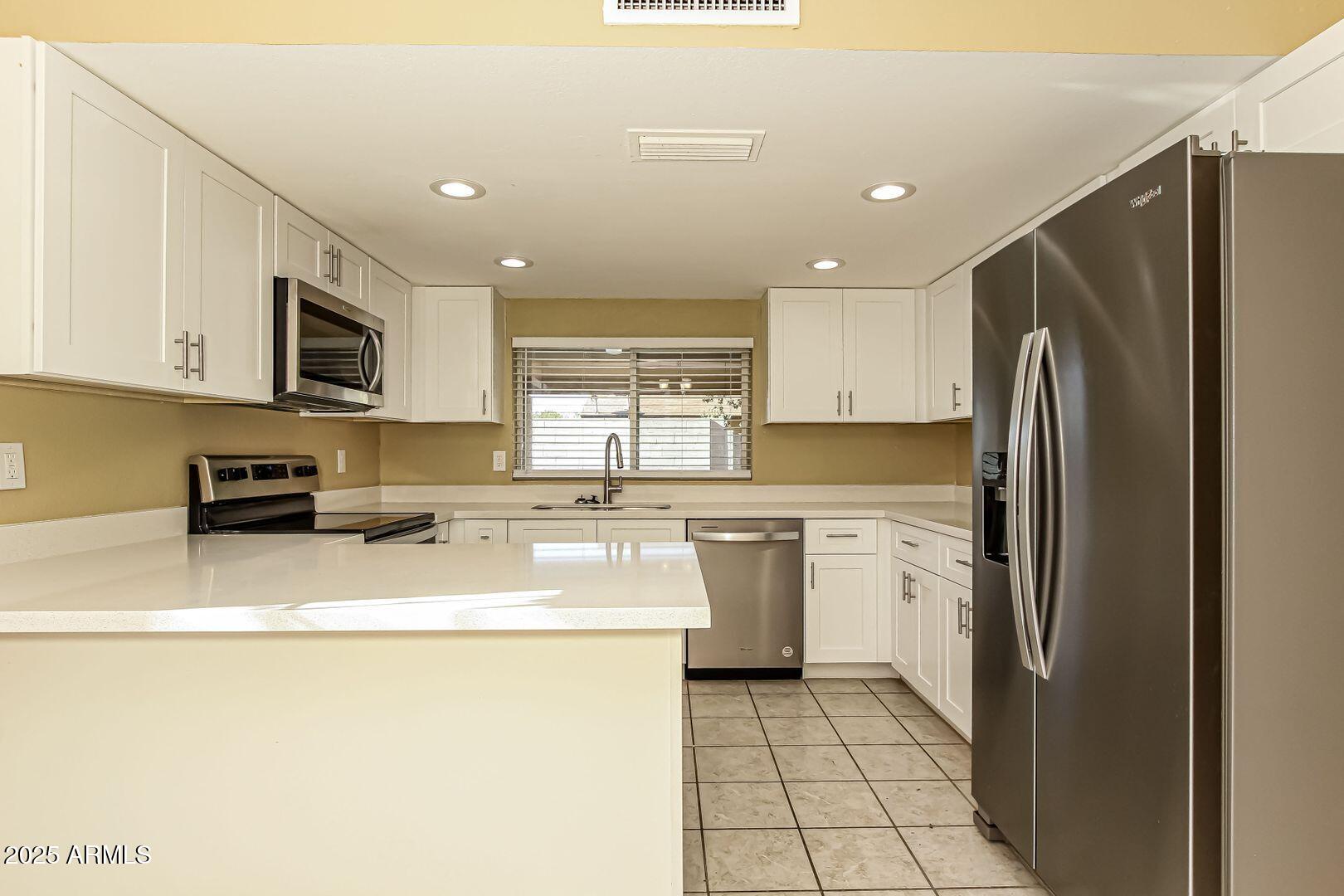4610 North 75th Drive Phoenix, AZ 85033 - Photo 3 of 14 a kitchen with a refrigerator a stove top oven a sink and dishwasher