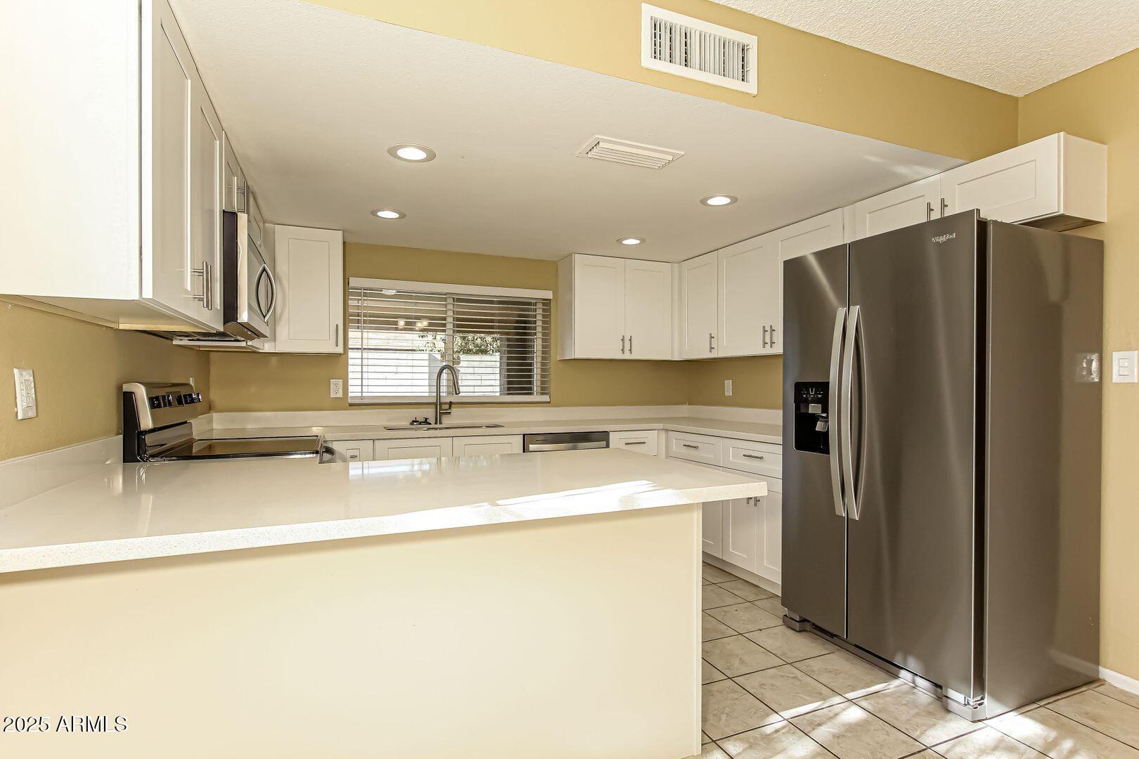 4610 North 75th Drive Phoenix, AZ 85033 - Photo 4 of 14 a kitchen with stainless steel appliances granite countertop a refrigerator a stove a sink and a microwave