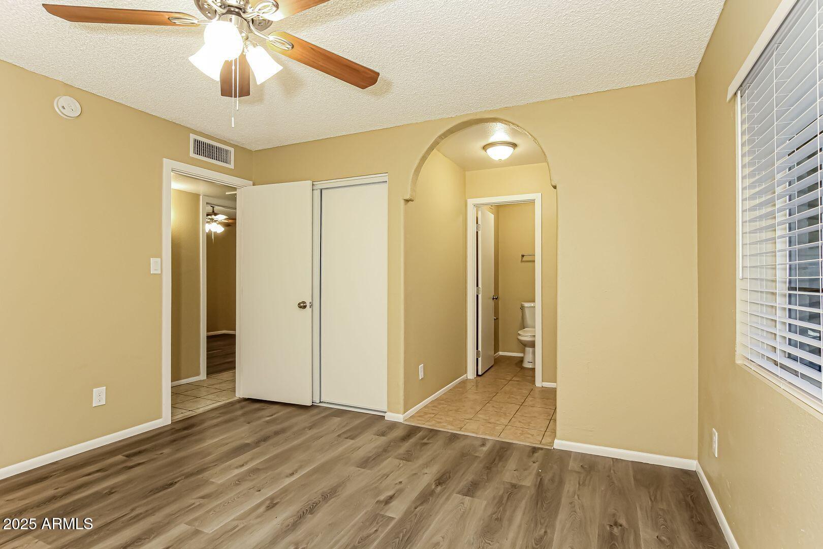 4610 North 75th Drive Phoenix, AZ 85033 - Photo 6 of 14 wooden floor in an empty room with a window