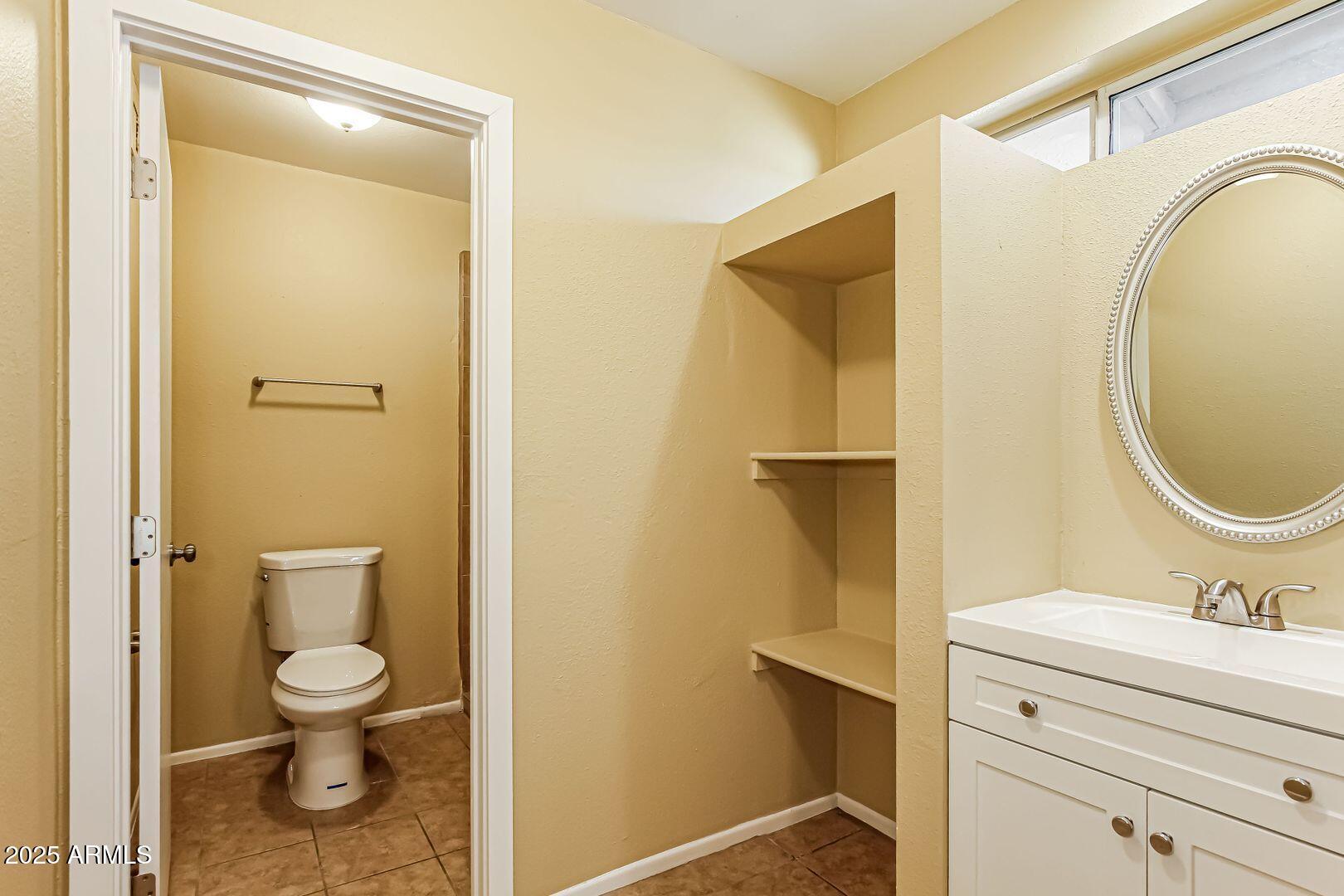 4610 North 75th Drive Phoenix, AZ 85033 - Photo 8 of 14 a bathroom with a granite countertop toilet a sink and a mirror