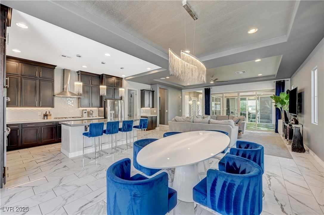 3943 Reyes Avenue Las Vegas, NV 89141 - Photo 11 of 93 Dining room featuring a tray ceiling, recessed lighting, and light marble finish floors