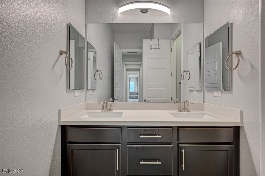 3943 Reyes Avenue Las Vegas, NV 89141 - Photo 27 of 93 Full bathroom featuring a textured wall and double vanity