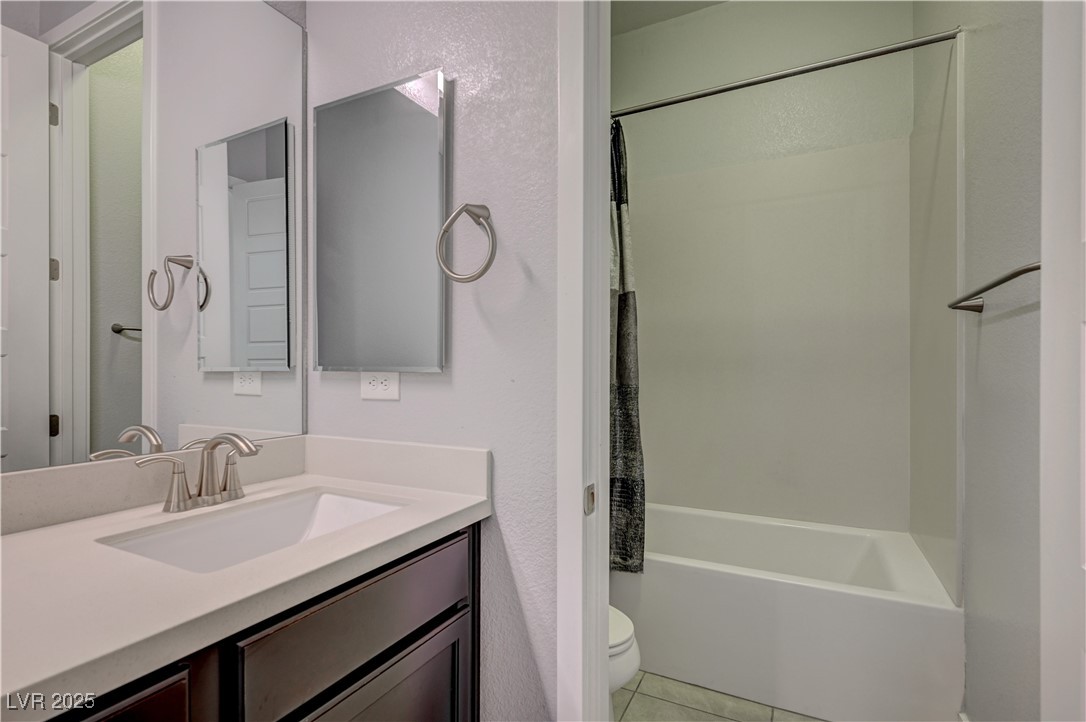 3943 Reyes Avenue Las Vegas, NV 89141 - Photo 28 of 93 Bathroom with vanity, light tile patterned floors, shower / tub combo with curtain, and a textured wall