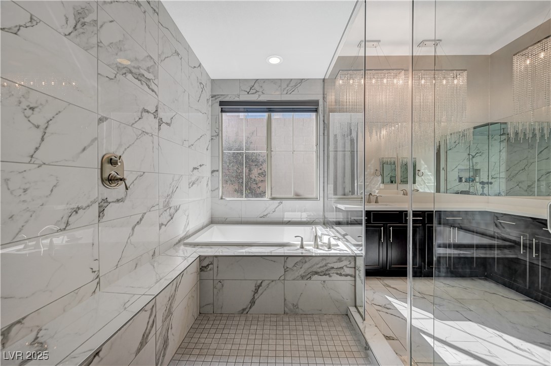 3943 Reyes Avenue Las Vegas, NV 89141 - Photo 33 of 93 Full bath with vanity, a garden tub, tile walls, recessed lighting, and a marble finish shower
