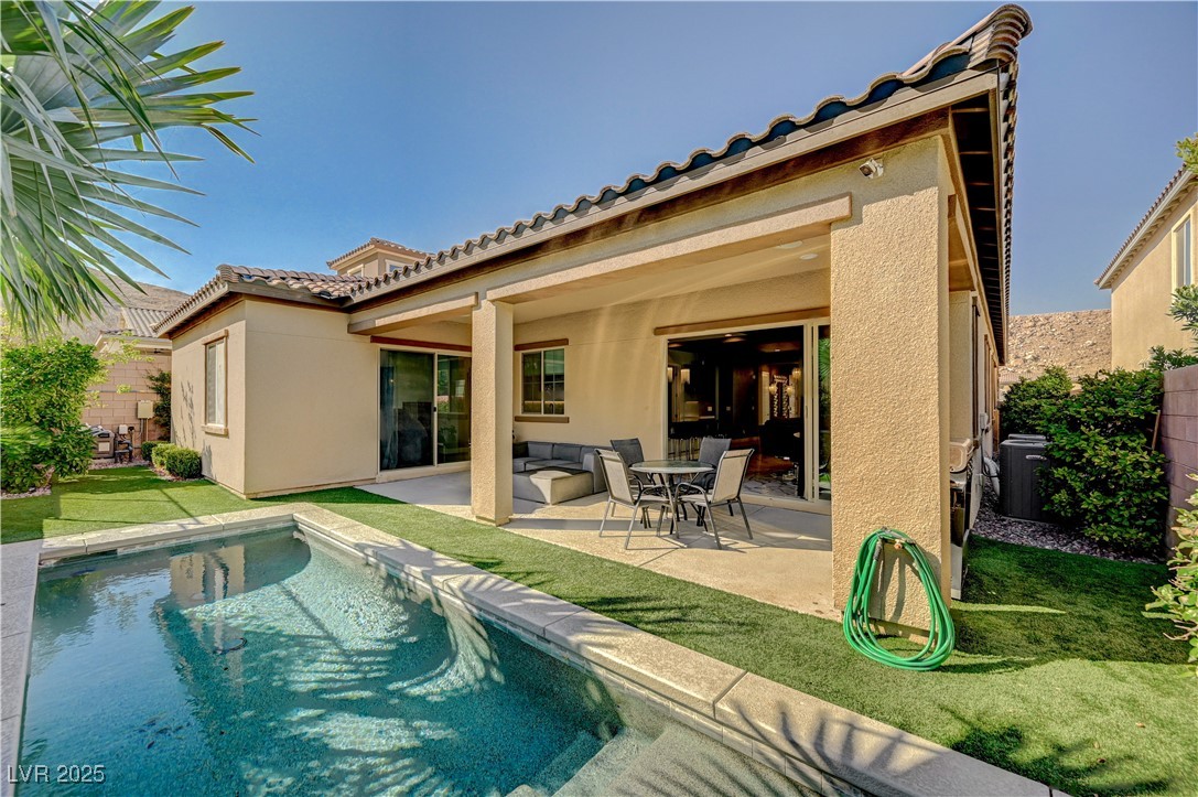 3943 Reyes Avenue Las Vegas, NV 89141 - Photo 54 of 93 Back of property featuring a patio, stucco siding, a yard, and a tiled roof