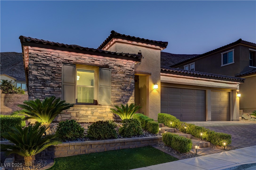 3943 Reyes Avenue Las Vegas, NV 89141 - Photo 78 of 93 Mediterranean / spanish-style house featuring stone siding, stucco siding, a garage, and decorative driveway