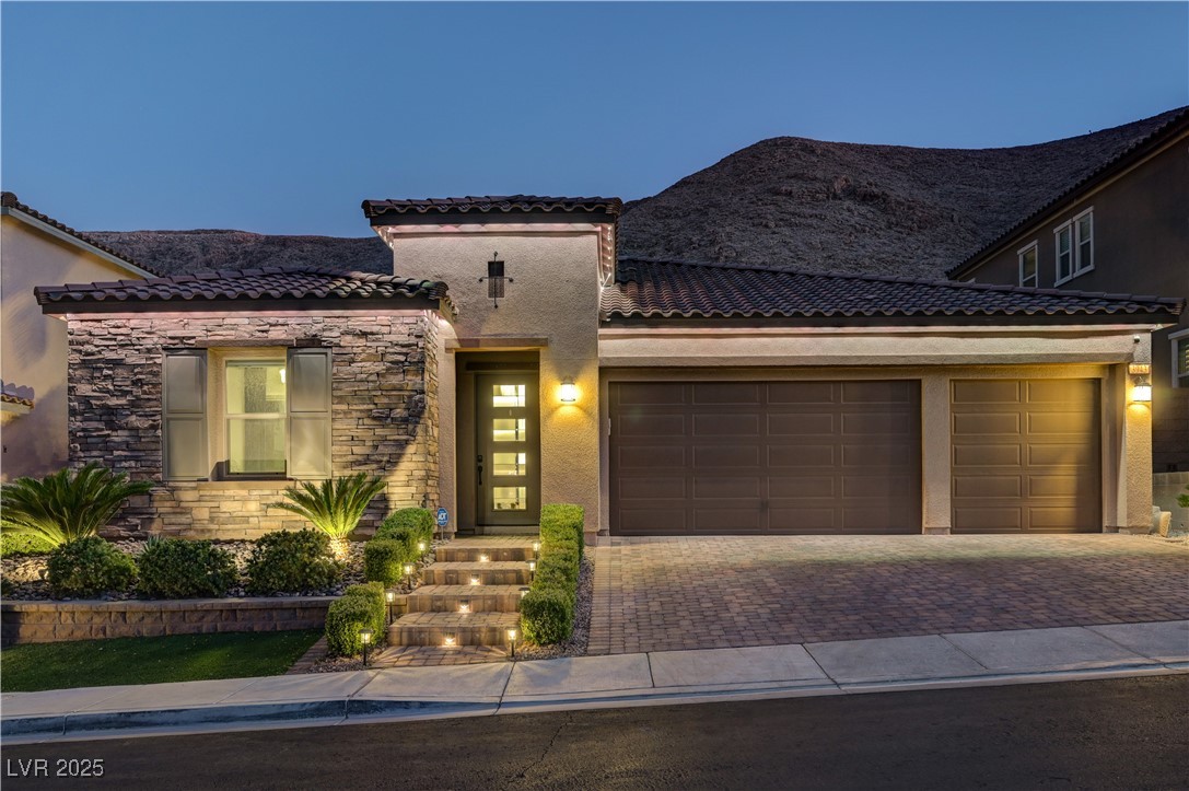 3943 Reyes Avenue Las Vegas, NV 89141 - Photo 80 of 93 Mediterranean / spanish-style house featuring stone siding, stucco siding, decorative driveway, a garage, and a tile roof