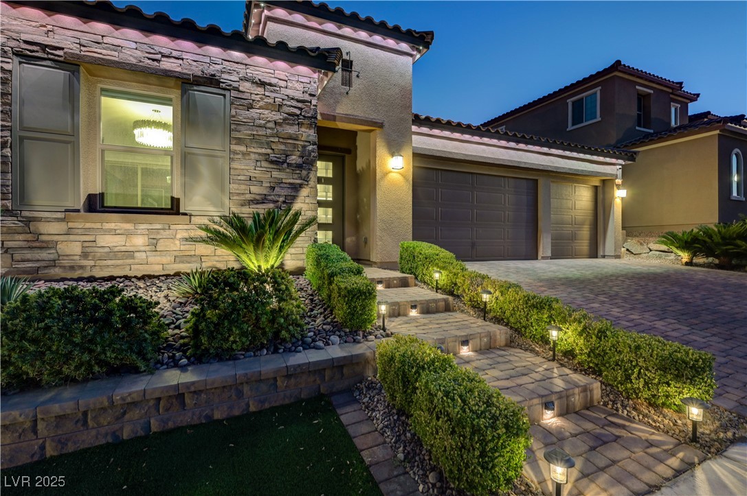 3943 Reyes Avenue Las Vegas, NV 89141 - Photo 82 of 93 Mediterranean / spanish-style house with stone siding, stucco siding, an attached garage, and decorative driveway