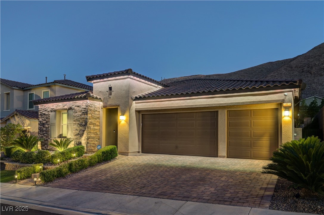 3943 Reyes Avenue Las Vegas, NV 89141 - Photo 83 of 93 Mediterranean / spanish house with stucco siding, decorative driveway, an attached garage, and a tile roof