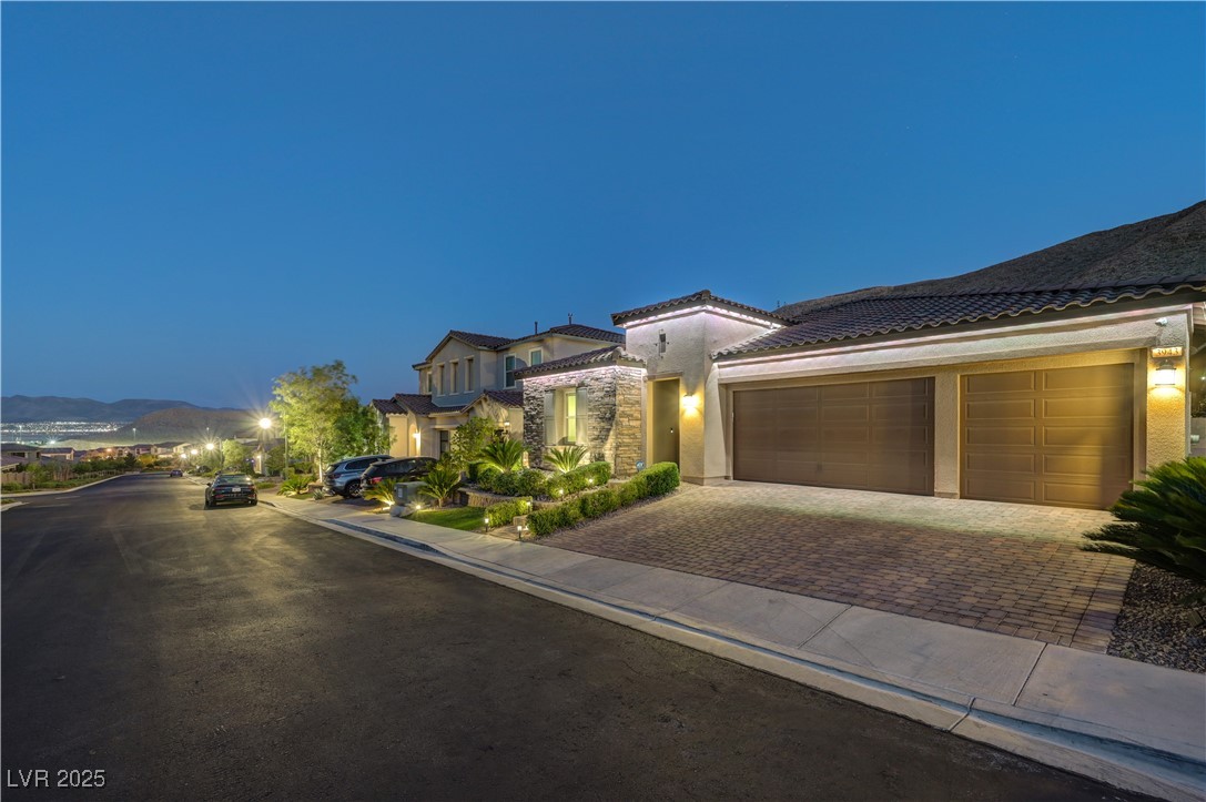 3943 Reyes Avenue Las Vegas, NV 89141 - Photo 84 of 93 View of front facade featuring stucco siding, decorative driveway, a garage, and a tiled roof