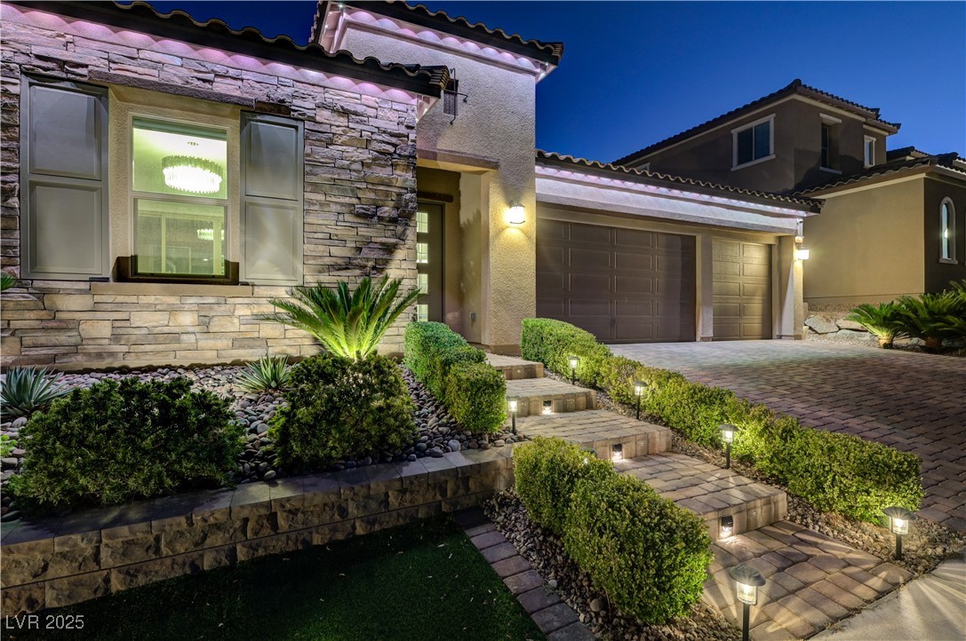 3943 Reyes Avenue Las Vegas, NV 89141 - Photo 88 of 93 Mediterranean / spanish home featuring stone siding, stucco siding, an attached garage, driveway, and a tiled roof