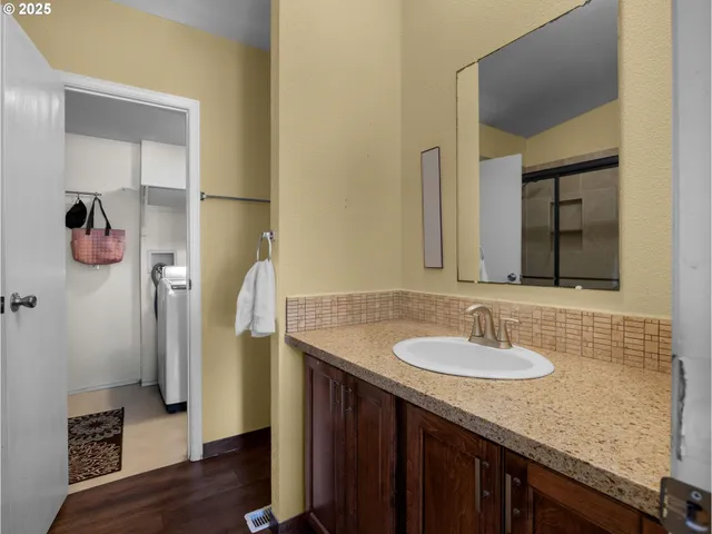 a bathroom with a granite countertop sink and a mirror