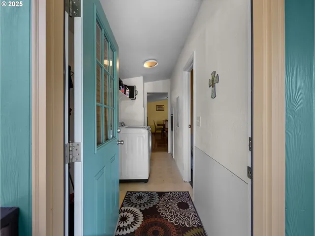 a view of a hallway with wooden floor windows and a living room