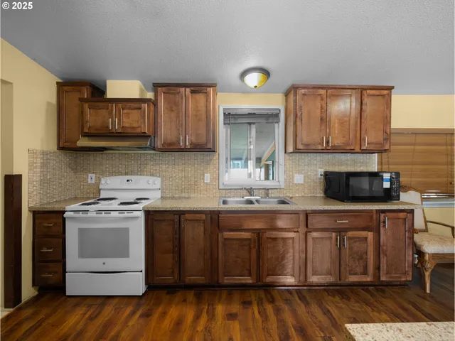 a kitchen with a sink cabinets and wooden floor