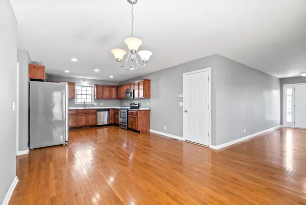 a view of a kitchen with a refrigerator and wooden floor