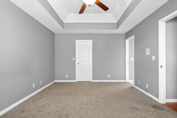 an empty room with closet and fan