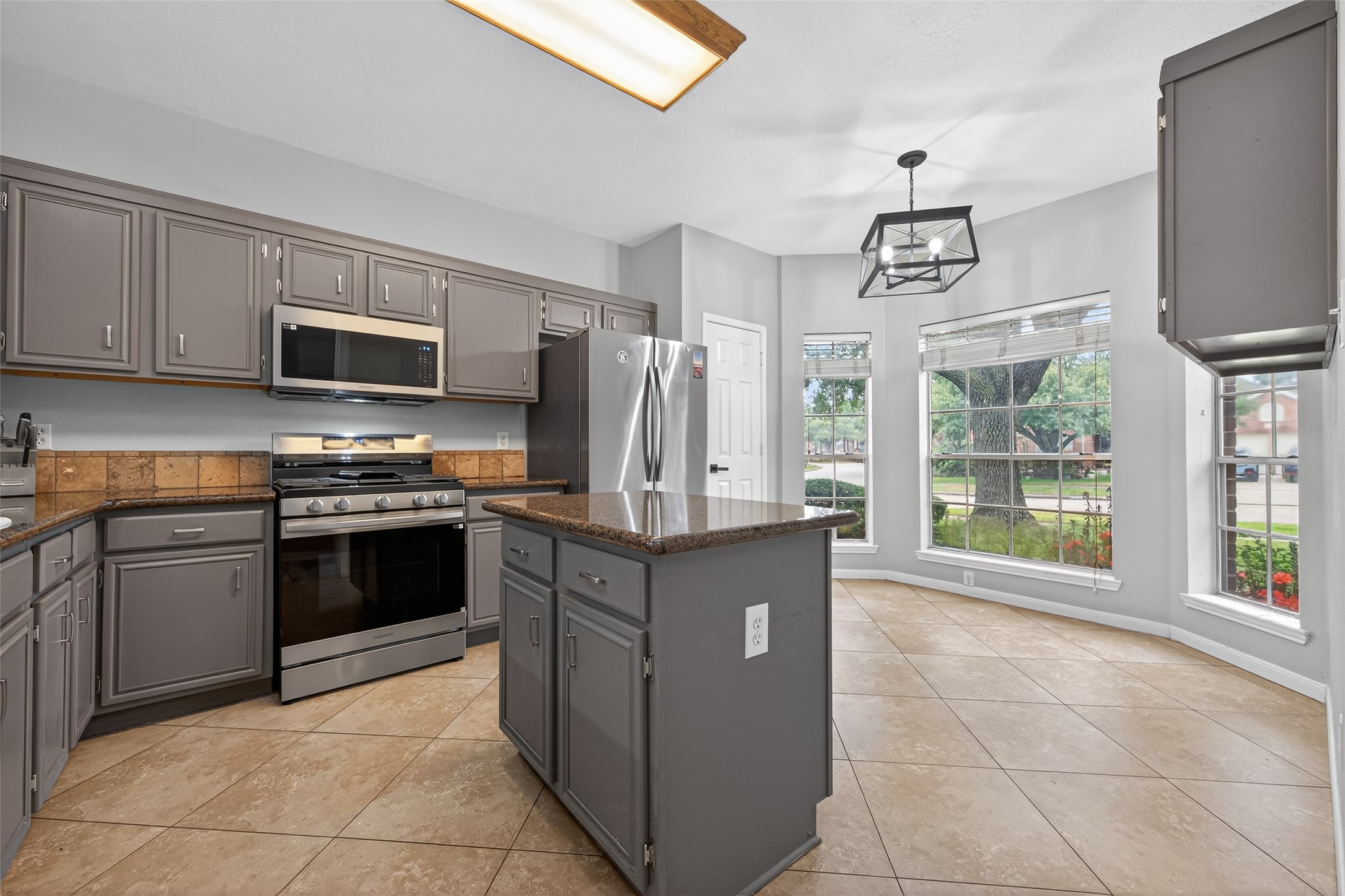 16902 Canyon Ridge Drive Spring, TX 77379 - Photo 11 of 43 a kitchen with granite countertop a stove top oven microwave and refrigerator