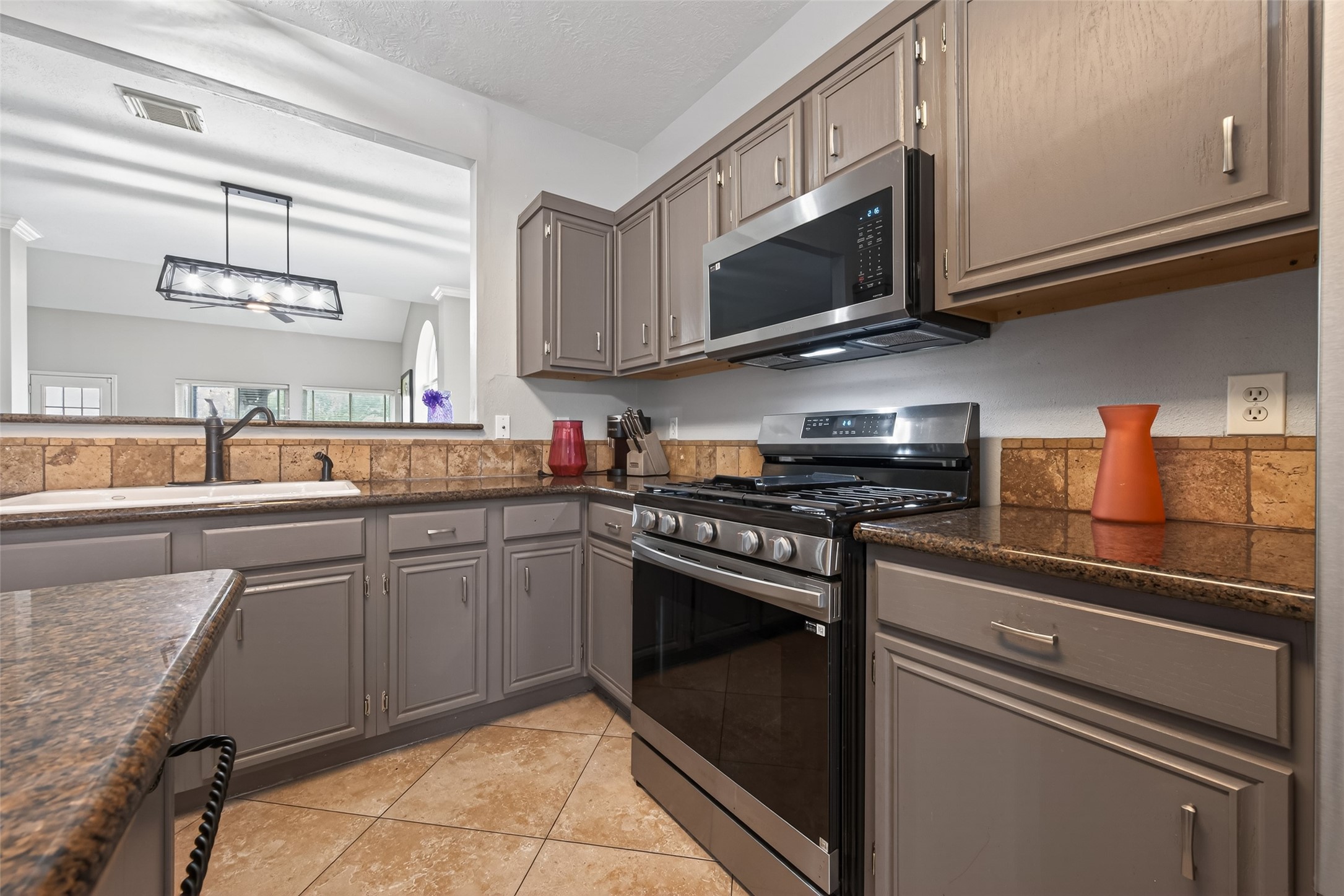 16902 Canyon Ridge Drive Spring, TX 77379 - Photo 16 of 43 a kitchen with stainless steel appliances granite countertop a sink and a stove