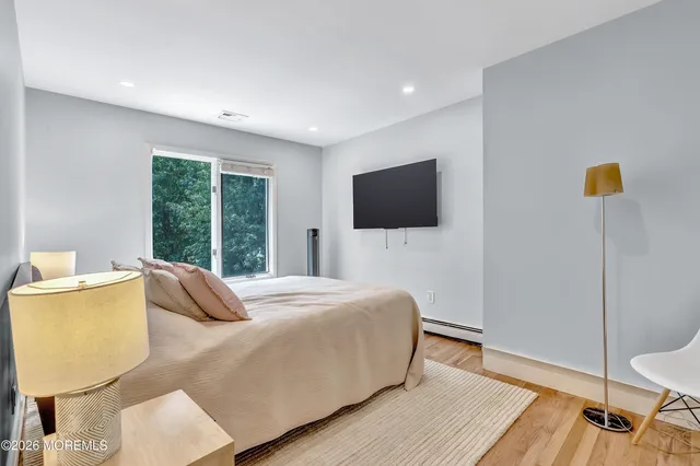a bedroom with a bed and wooden floor