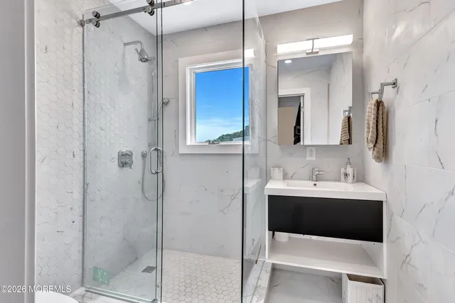 a bathroom with a sink shower and a mirror