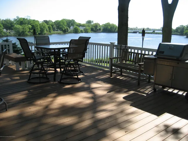 a view of a roof deck with table and chairs and wooden floor