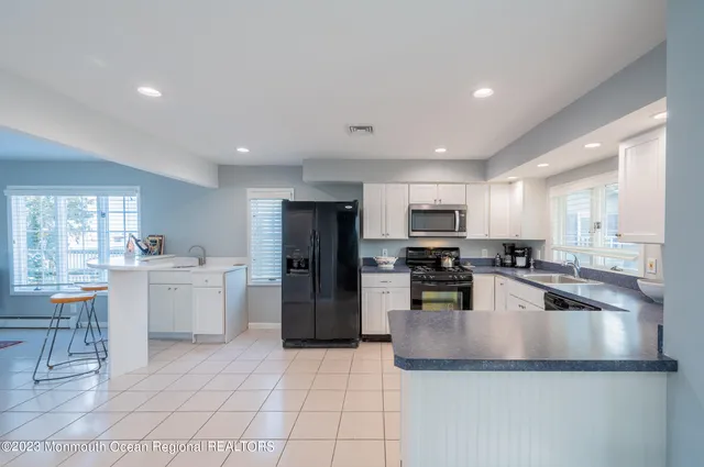 a large kitchen with a large counter top stainless steel appliances and cabinets