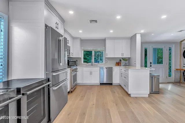 a kitchen with white cabinets and stainless steel appliances