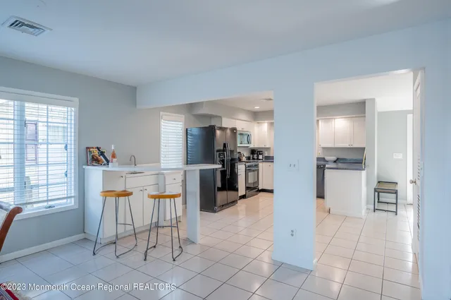 a view of kitchen with furniture and refrigerator
