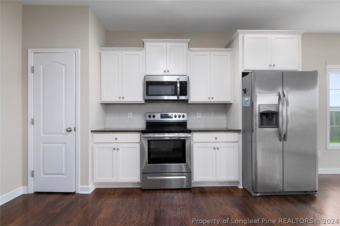 3631 Thrower Road Hope Mills, NC 28348 - Photo 13 of 50 a kitchen with a refrigerator stove and white cabinets