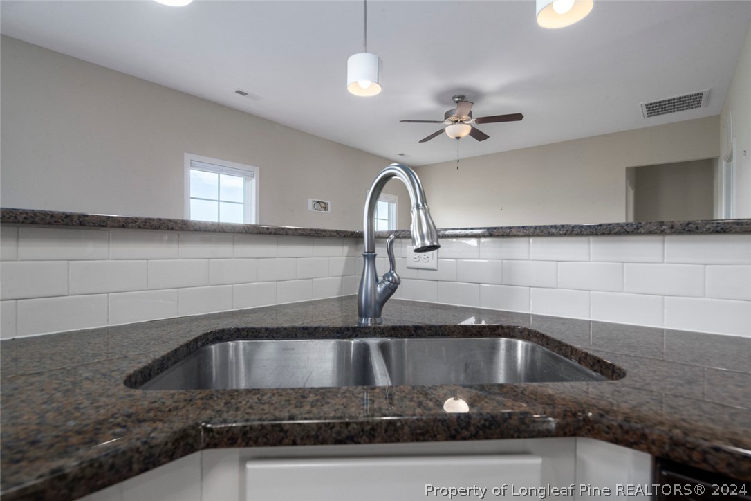 3631 Thrower Road Hope Mills, NC 28348 - Photo 17 of 50 a kitchen with a sink a faucet cabinets and a stove