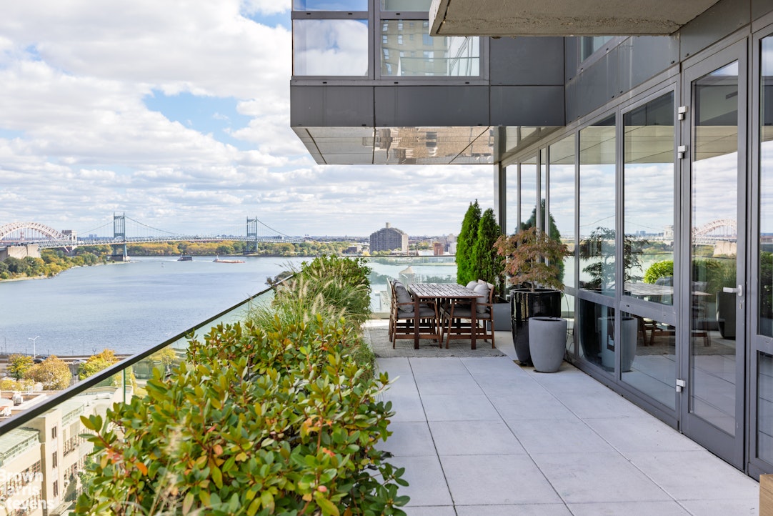 302 East 96th Street, Unit PH1 Manhattan, NY 10128 - Photo 2 of 13 a balcony with table and chairs and potted plants