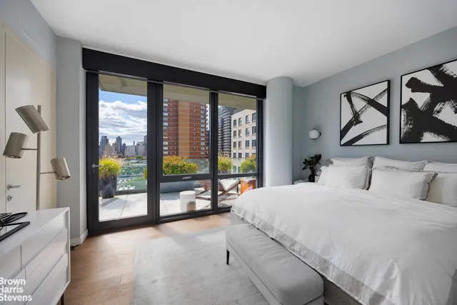 a bedroom with a large bed and a large window with the outer view