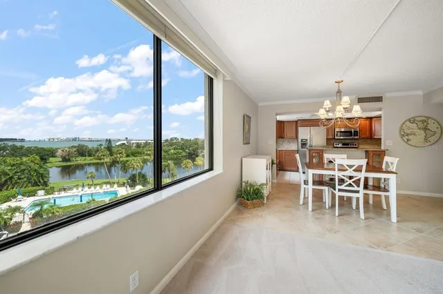 a dining room with furniture water view and a floor to ceiling window