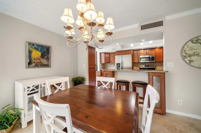 a view of a dining room with furniture and chandelier