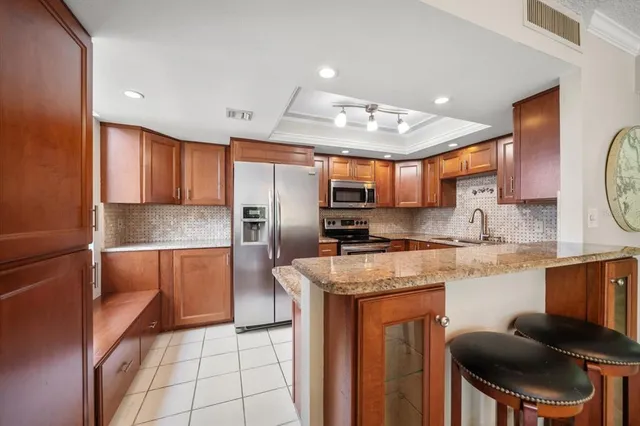 a kitchen with stainless steel appliances granite countertop a stove refrigerator sink and cabinets