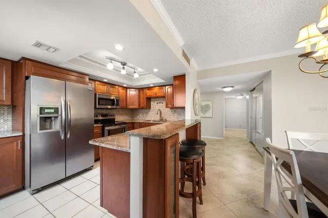 a kitchen with stainless steel appliances granite countertop a sink a stove and a refrigerator