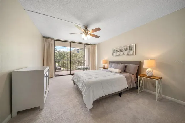 a spacious bedroom with a large bed and a chandelier