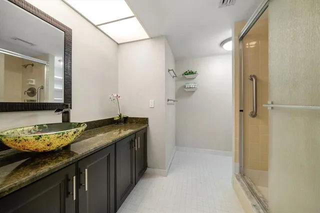 a bathroom with a granite countertop sink and a mirror