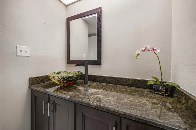 a bathroom with a granite countertop sink and a mirror