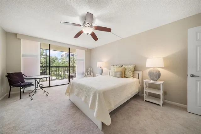 a bedroom with a bed a chair and a large window